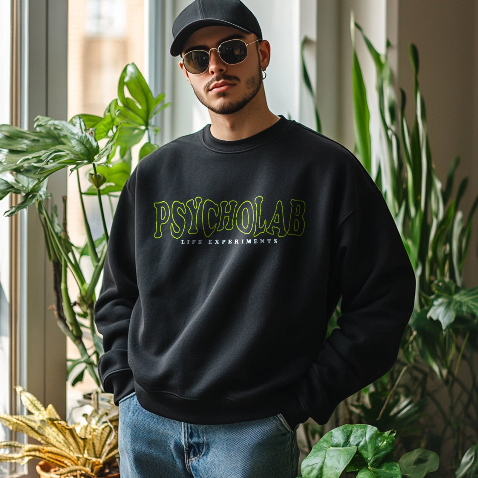 Ein Modell trägt das Sweatshirt Anamorphic Black von PsychoLab, perfekt kombiniert mit einer stylischen Sonnenbrille für einen trendigen Look.