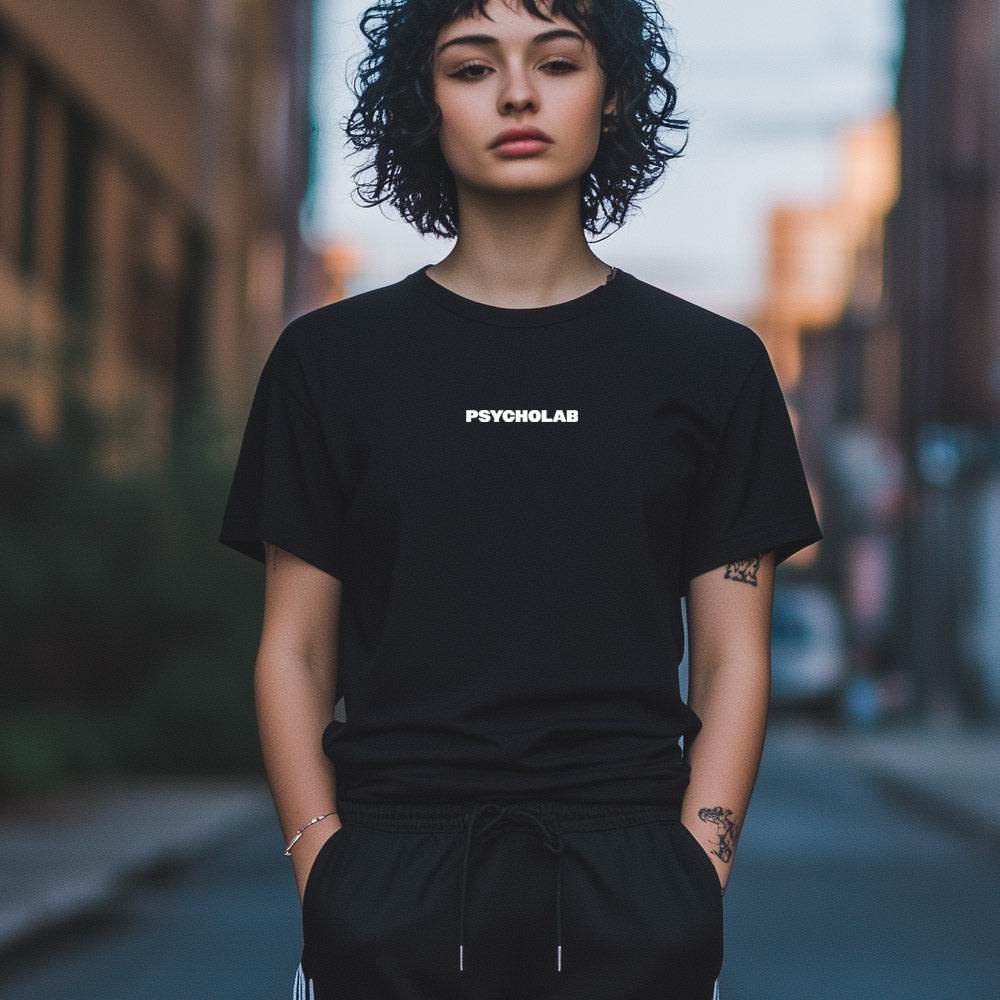 Frau trägt das Women Shirt Title Black von PsychoLab, minimalistisches Design mit klarem Title-Print auf schwarzer Bio-Baumwolle, ideal für urbane Looks, psycholab