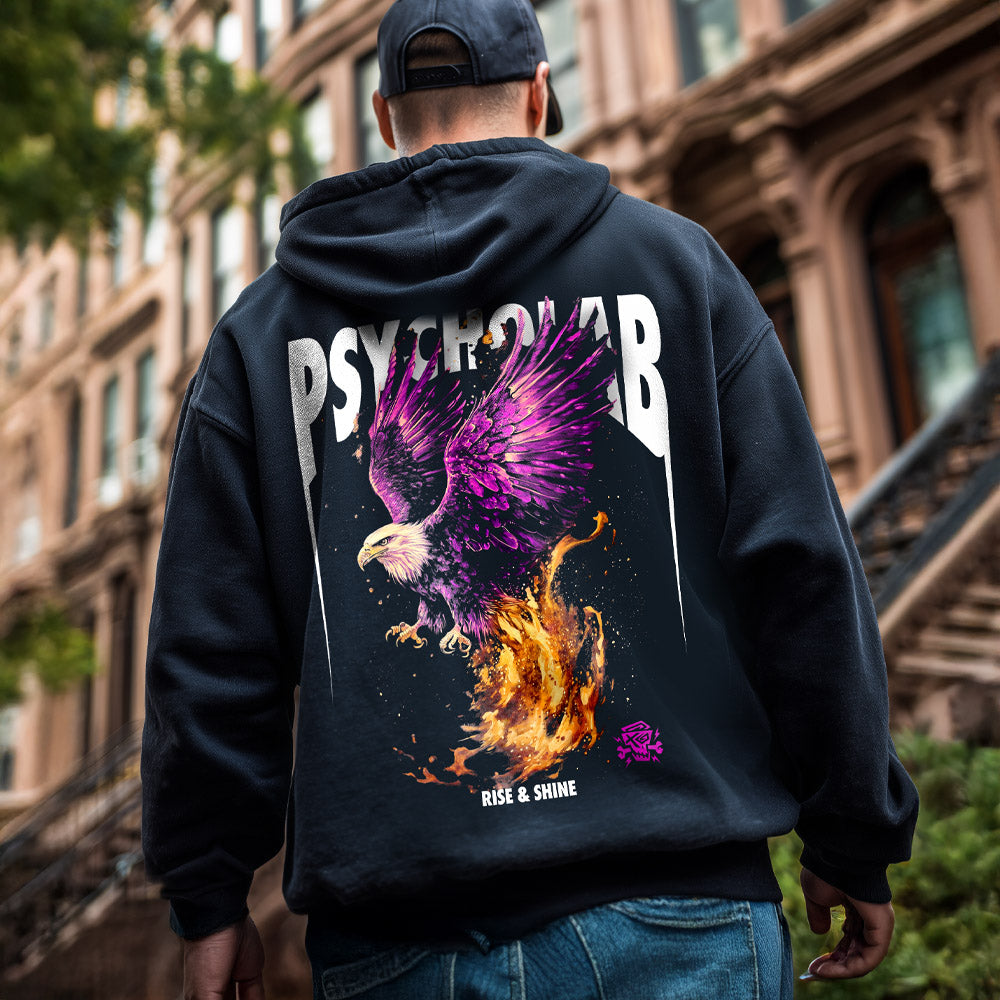 Der Hoodie Phoenix Black von PsychoLab zeigt ein lebhaftes Phönix-Motiv auf der Rückseite, das Stärke und Wiedergeburt symbolisiert, während der Träger auf einer urbanen Treppe posiert.